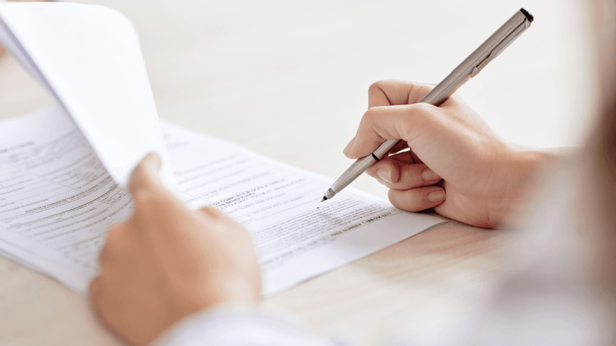 There is an image of a person signing a contract